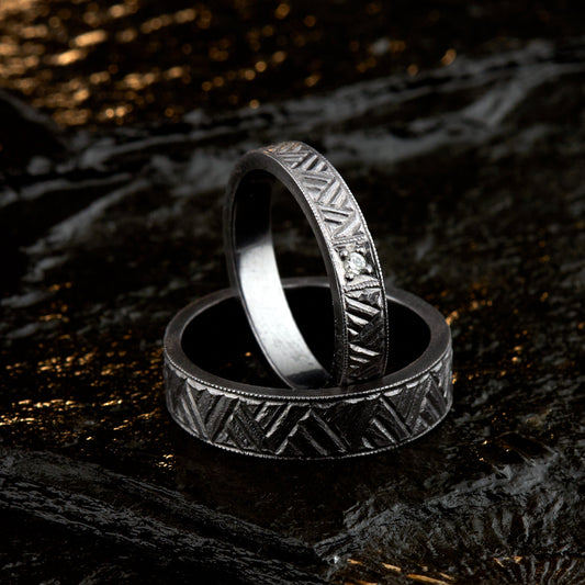 Exklusive Vintage Trauringe aus massivem Tantal. Handgefertigte Schlag-Gravur mit pneumatischem Hammer-Stichel für eine mattierte, historische Textur. Feiner Millegrain-Rand an den Kanten. Damenring 4mm breit mit 2mm Diamant (Brillantschliff, TW/si). Herrenring 6mm breit, massiv und dunkelgrau. Höchste Goldschmiedekunst aus eigener Werkstatt in Deutschland. Keine Industrieware, kein CNC. Biokompatibler Schmuck für Allergiker. Einzigartige, haptisch erlebbare Oberflächenstruktur.