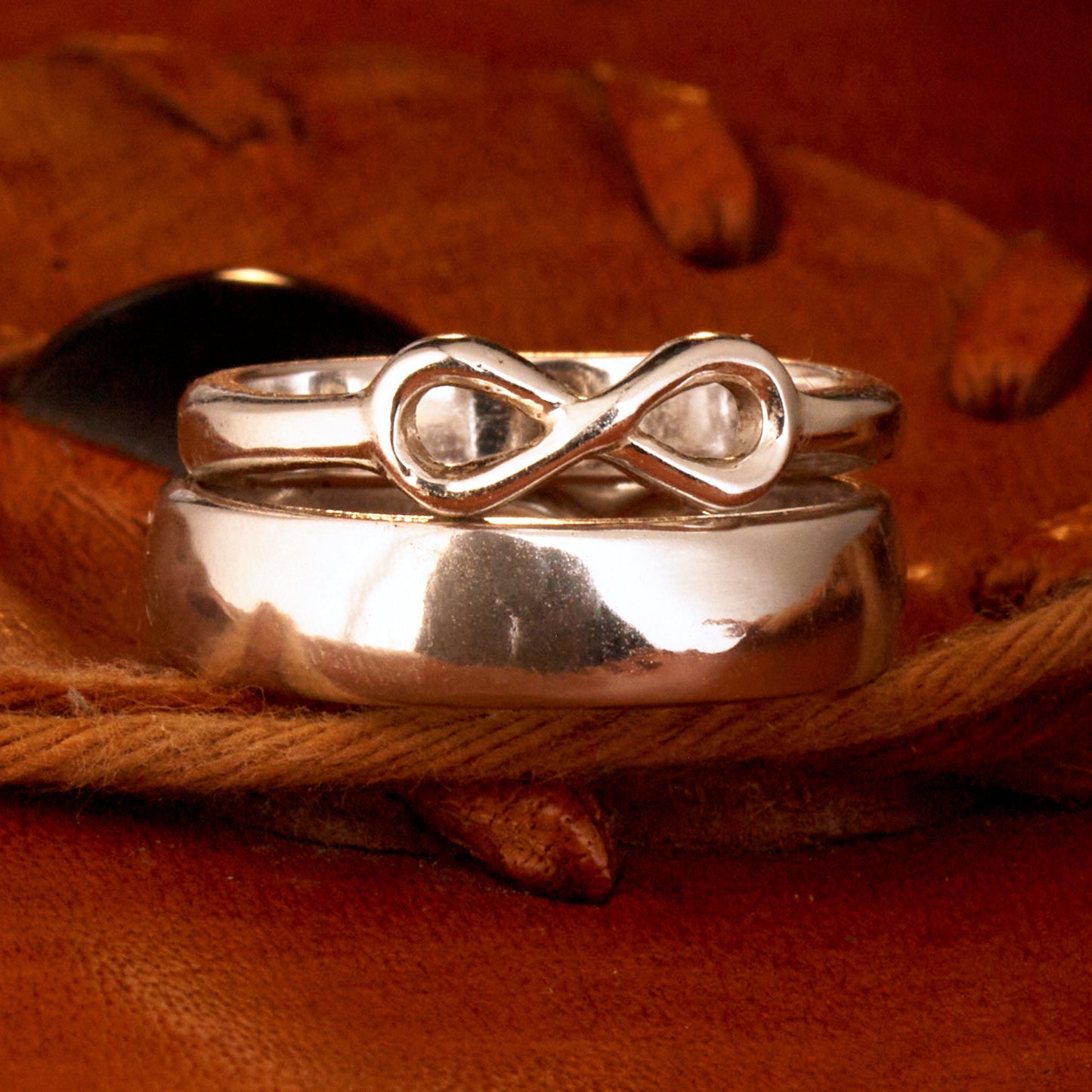 Handgefertigter Statement-Partnerring aus poliertem 925 Silber von Silberschweif mit großer Unendlichkeitsschleife (6x14mm). Die Schiene verjüngt sich elegant zum Motiv. Massiver 6mm Herrenring aus Silber. In der Innenansicht zeigt sich das fest eingravierte Unendlichkeits-Symbol als geheimes Zeichen der Verbundenheit.  Das Partnerring-Set „Ewigkeit“ zeigt das plastische Design des Damenrings und die spiegelnde Oberfläche des massiven Herrenrings