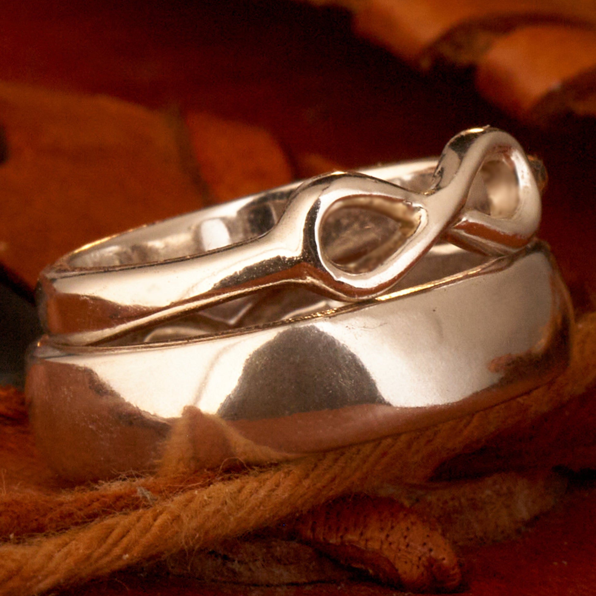  Handgefertigter Statement-Partnerring aus poliertem 925 Silber von Silberschweif mit großer Unendlichkeitsschleife (6x14mm). Die Schiene verjüngt sich elegant zum Motiv. Massiver 6mm Herrenring aus Silber. In der Innenansicht zeigt sich das fest eingravierte Unendlichkeits-Symbol als geheimes Zeichen der Verbundenheit.  Das Partnerring-Set „Ewigkeit“ zeigt das plastische Design des Damenrings und die spiegelnde Oberfläche des massiven Herrenrings