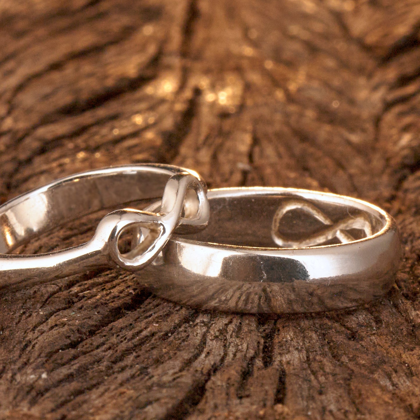  Handgefertigter Statement-Partnerring aus poliertem 925 Silber von Silberschweif mit großer Unendlichkeitsschleife (6x14mm). Die Schiene verjüngt sich elegant zum Motiv. Massiver 6mm Herrenring aus Silber. In der Innenansicht zeigt sich das fest eingravierte Unendlichkeits-Symbol als geheimes Zeichen der Verbundenheit.  Das Partnerring-Set „Ewigkeit“ zeigt das plastische Design des Damenrings und die spiegelnde Oberfläche des massiven Herrenrings