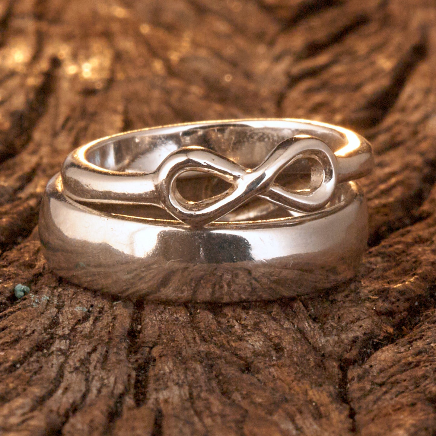  Handgefertigter Statement-Partnerring aus poliertem 925 Silber von Silberschweif mit großer Unendlichkeitsschleife (6x14mm). Die Schiene verjüngt sich elegant zum Motiv. Massiver 6mm Herrenring aus Silber. In der Innenansicht zeigt sich das fest eingravierte Unendlichkeits-Symbol als geheimes Zeichen der Verbundenheit.  Das Partnerring-Set „Ewigkeit“ zeigt das plastische Design des Damenrings und die spiegelnde Oberfläche des massiven Herrenrings