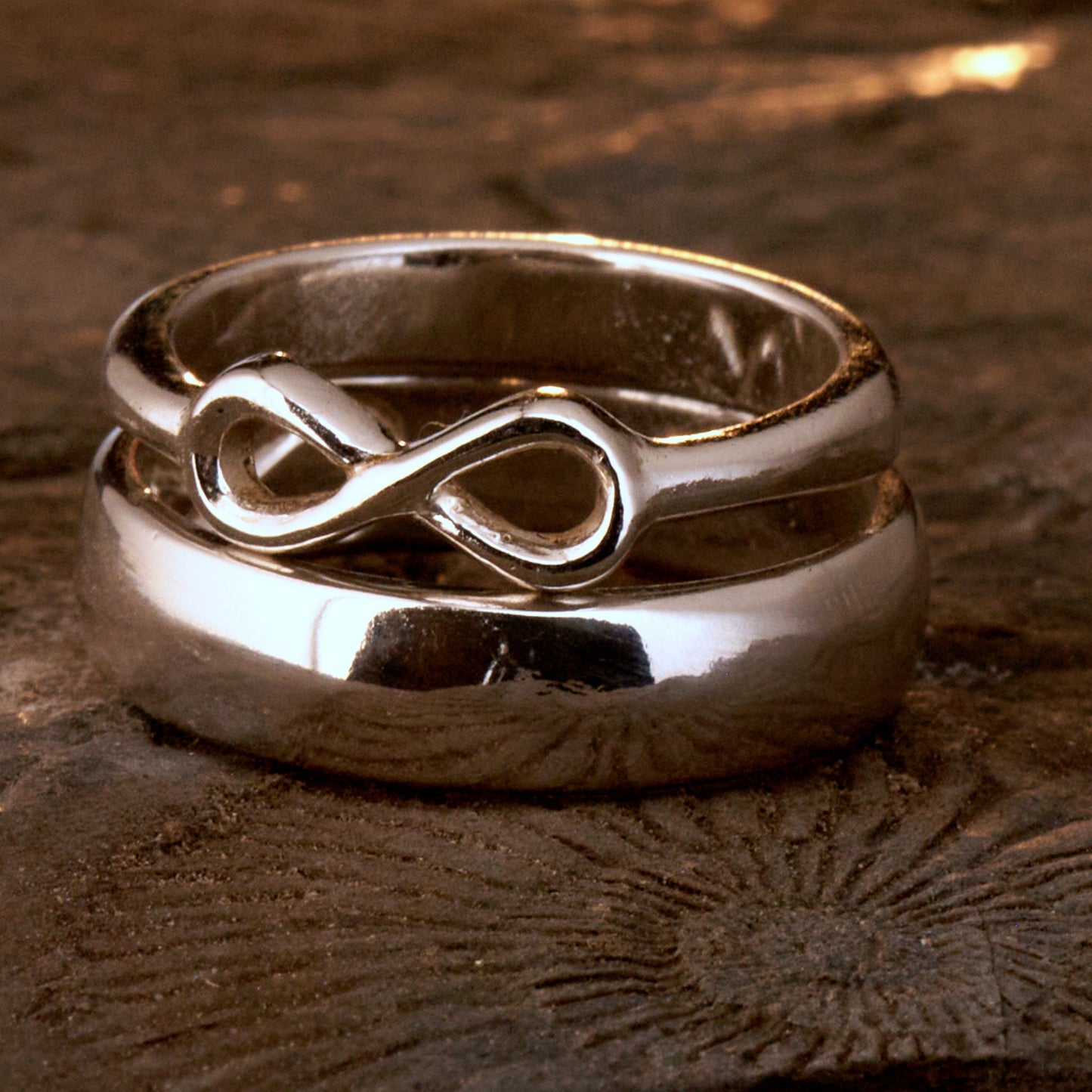  Handgefertigter Statement-Partnerring aus poliertem 925 Silber von Silberschweif mit großer Unendlichkeitsschleife (6x14mm). Die Schiene verjüngt sich elegant zum Motiv. Massiver 6mm Herrenring aus Silber. In der Innenansicht zeigt sich das fest eingravierte Unendlichkeits-Symbol als geheimes Zeichen der Verbundenheit.  Das Partnerring-Set „Ewigkeit“ zeigt das plastische Design des Damenrings und die spiegelnde Oberfläche des massiven Herrenrings