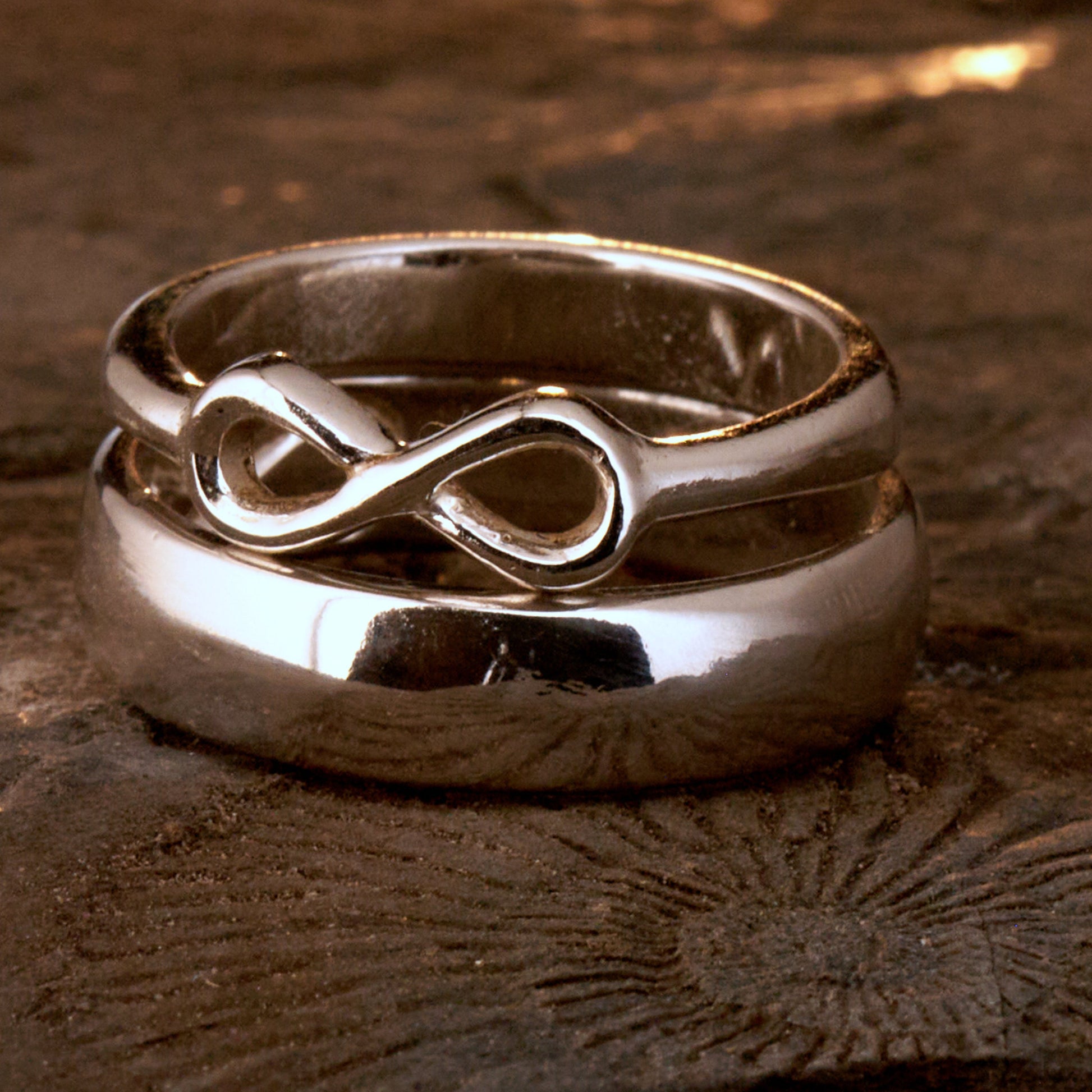  Handgefertigter Statement-Partnerring aus poliertem 925 Silber von Silberschweif mit großer Unendlichkeitsschleife (6x14mm). Die Schiene verjüngt sich elegant zum Motiv. Massiver 6mm Herrenring aus Silber. In der Innenansicht zeigt sich das fest eingravierte Unendlichkeits-Symbol als geheimes Zeichen der Verbundenheit.  Das Partnerring-Set „Ewigkeit“ zeigt das plastische Design des Damenrings und die spiegelnde Oberfläche des massiven Herrenrings