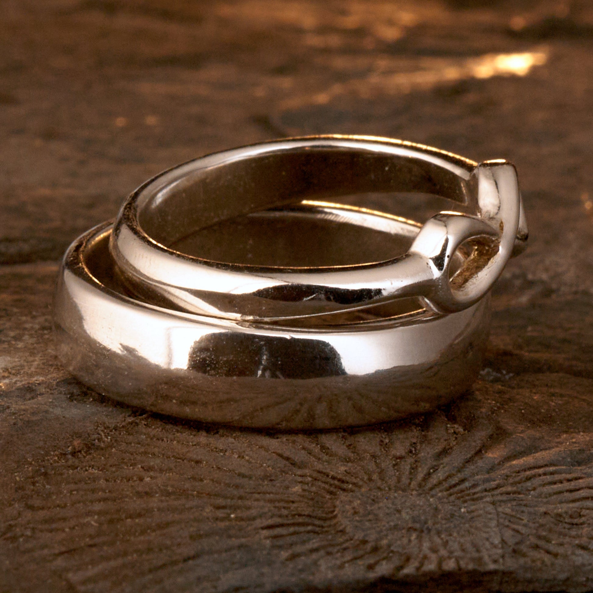  Handgefertigter Statement-Partnerring aus poliertem 925 Silber von Silberschweif mit großer Unendlichkeitsschleife (6x14mm). Die Schiene verjüngt sich elegant zum Motiv. Massiver 6mm Herrenring aus Silber. In der Innenansicht zeigt sich das fest eingravierte Unendlichkeits-Symbol als geheimes Zeichen der Verbundenheit.  Das Partnerring-Set „Ewigkeit“ zeigt das plastische Design des Damenrings und die spiegelnde Oberfläche des massiven Herrenrings