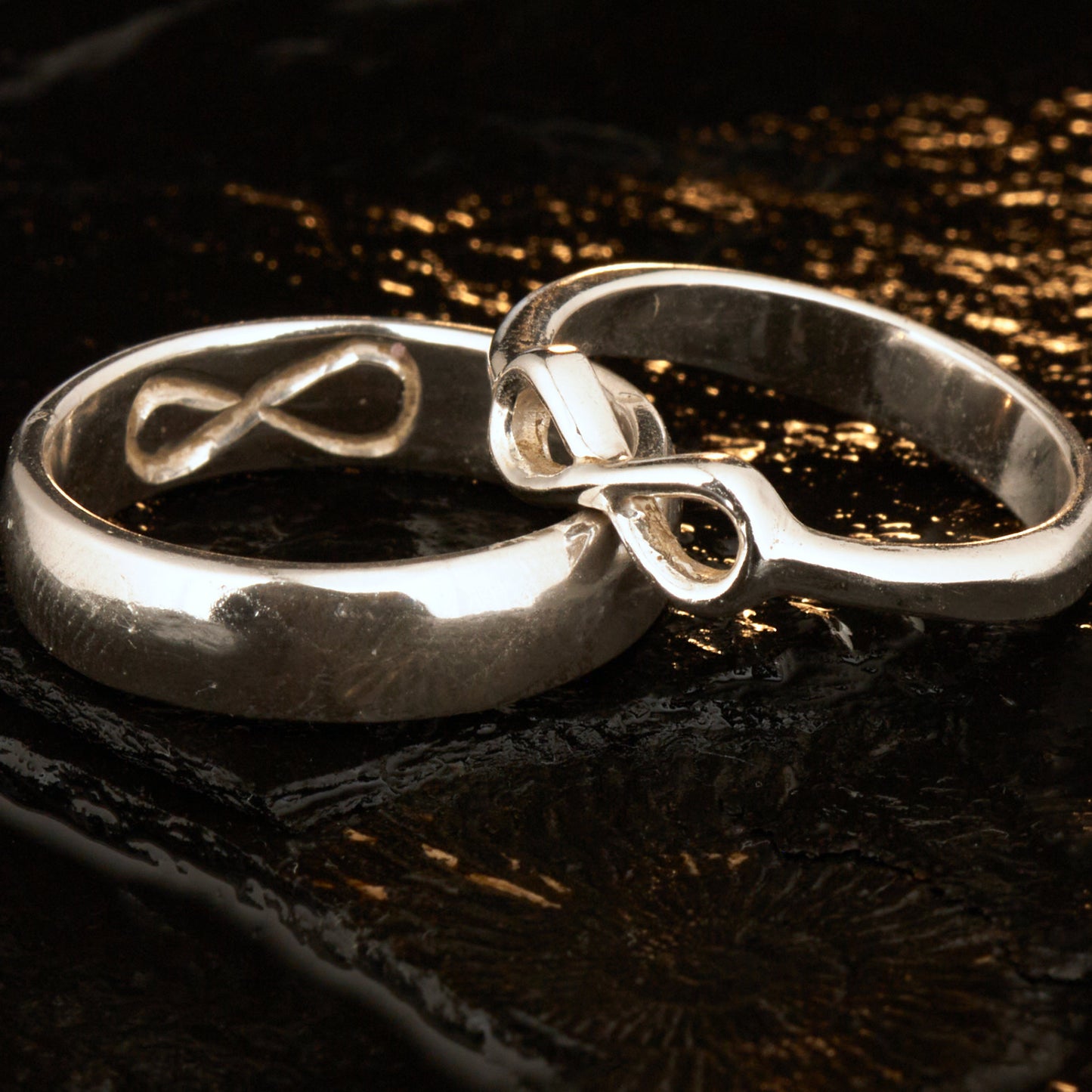  Handgefertigter Statement-Partnerring aus poliertem 925 Silber von Silberschweif mit großer Unendlichkeitsschleife (6x14mm). Die Schiene verjüngt sich elegant zum Motiv. Massiver 6mm Herrenring aus Silber. In der Innenansicht zeigt sich das fest eingravierte Unendlichkeits-Symbol als geheimes Zeichen der Verbundenheit.  Das Partnerring-Set „Ewigkeit“ zeigt das plastische Design des Damenrings und die spiegelnde Oberfläche des massiven Herrenrings