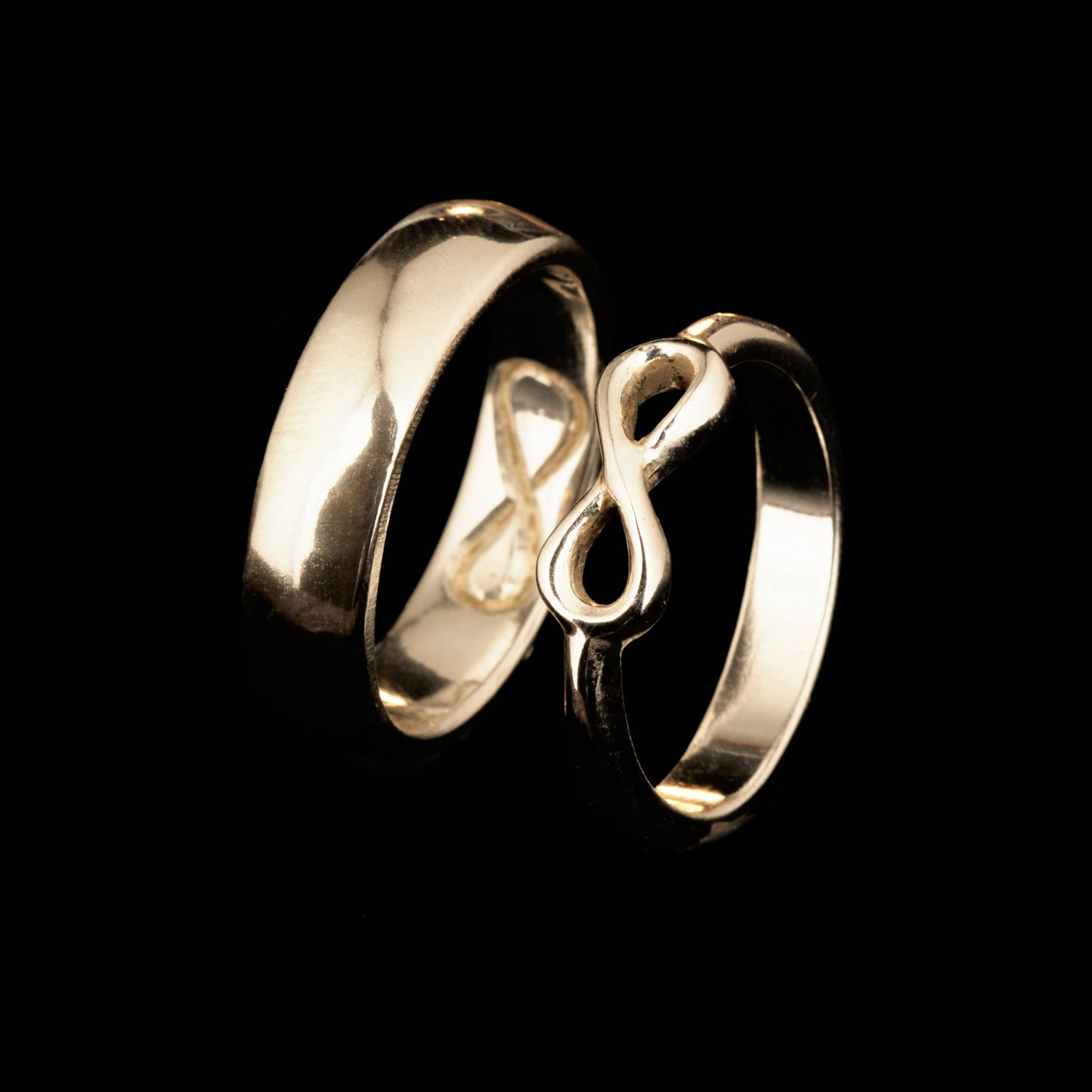  Handgefertigter Statement-Partnerring aus poliertem 925 Silber von Silberschweif mit großer Unendlichkeitsschleife (6x14mm). Die Schiene verjüngt sich elegant zum Motiv. Massiver 6mm Herrenring aus Silber. In der Innenansicht zeigt sich das fest eingravierte Unendlichkeits-Symbol als geheimes Zeichen der Verbundenheit.  Das Partnerring-Set „Ewigkeit“ zeigt das plastische Design des Damenrings und die spiegelnde Oberfläche des massiven Herrenrings